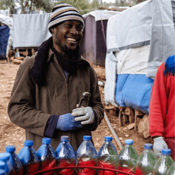 Homme souriant lors de la construction de poubelles dans l'ancien camp de l'île Greque de Samos